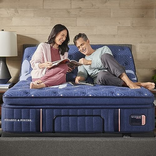 Couple relaxing on an adjustable bed with a magazine.