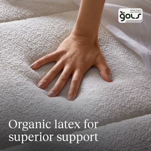 Hand pressing on organic latex mattress with GOLS logo.
